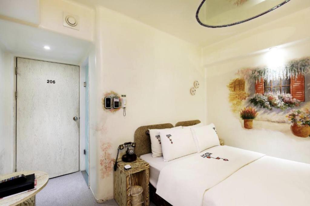 1 dormitorio blanco con 1 cama y una foto en la pared en Amant Hotel, en Goyang
