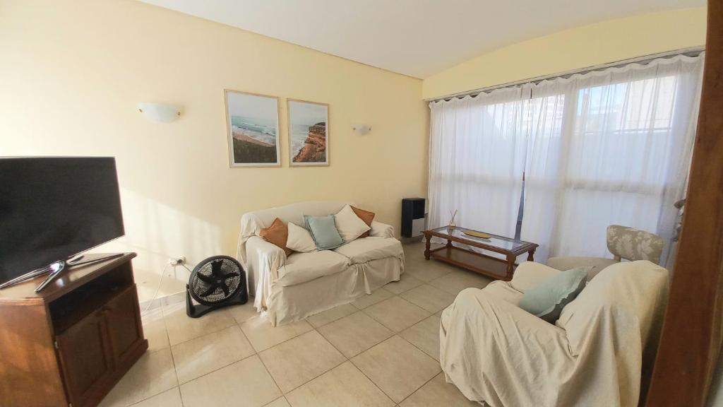 馬德普拉塔的住宿－Alma de playa，客厅配有2把椅子和平面电视