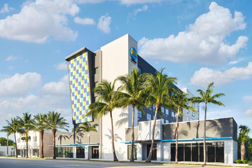 a building with palm trees in front of it at Tru By Hilton Ft Lauderdale Airport in Dania Beach