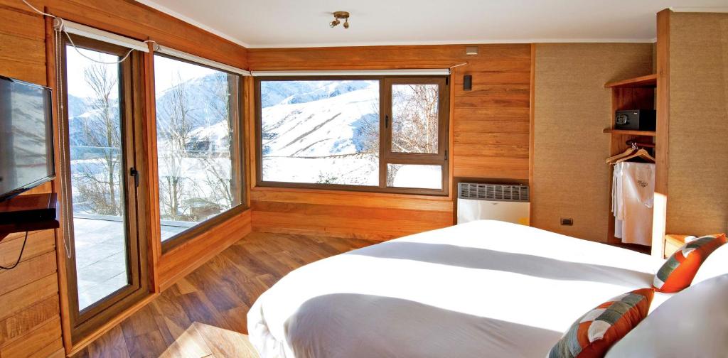 a bedroom with a bed and a large window at La Cornisa Lodge in Santiago