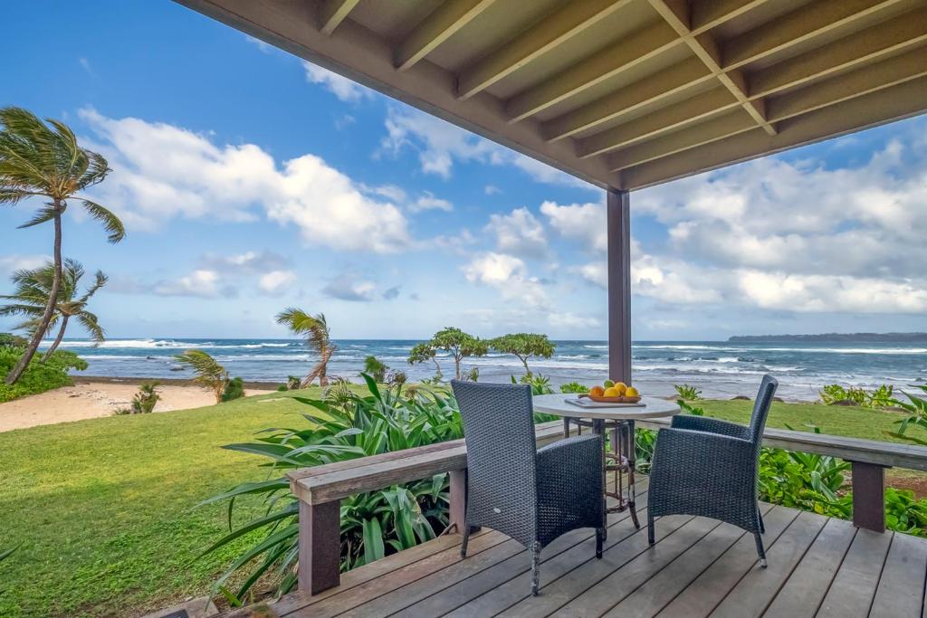 a deck with a table and chairs and the ocean at Hanalei Colony Resort I-1 in Hanalei