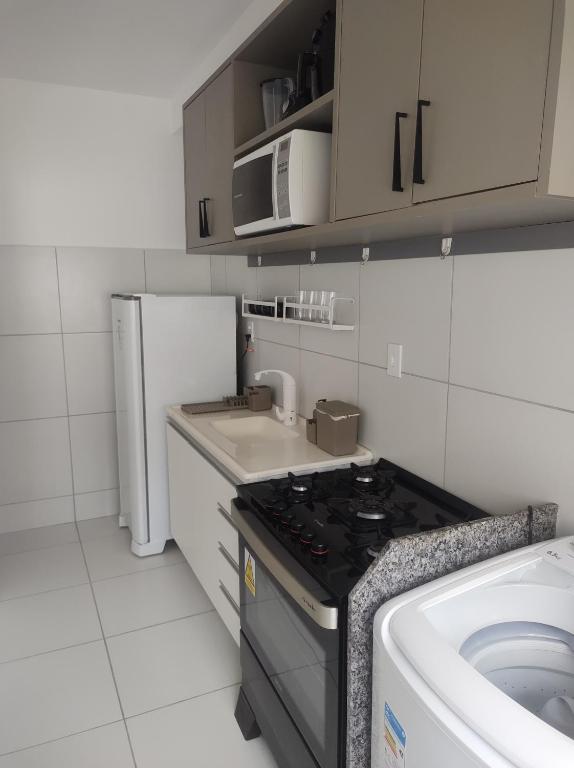 a small kitchen with a stove and a sink at Apt há 10 minutos da Praia. in São-José-do-Ribamar