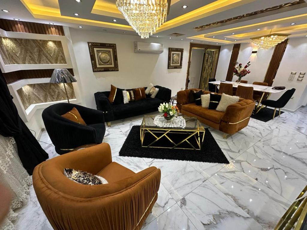 uma grande sala de estar com sofás e uma mesa em شقة مفروشة للايجار بالمهندسين no Cairo