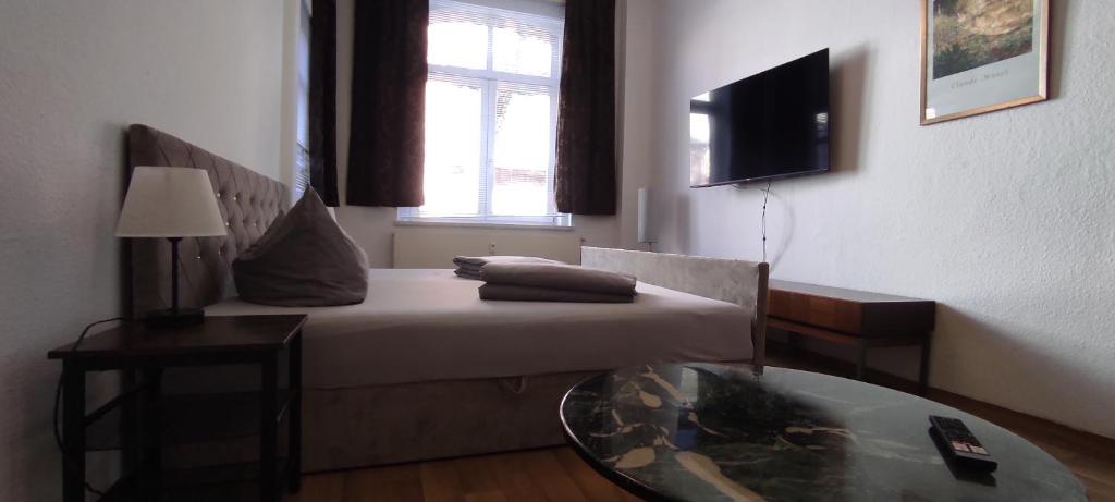 Cette petite chambre comprend un lit et une table en verre. dans l'établissement Apartment Cottbus City - Erdgeschoss, à Cottbus