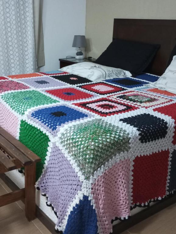 - une couette colorée sur un lit dans une chambre dans l'établissement Casa da roça, à Espera Feliz