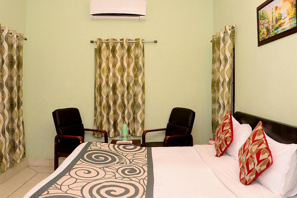 a room with a bed and two chairs in it at Collection O 4255 Day Night Guest House And Restaurant in Mahāmandir