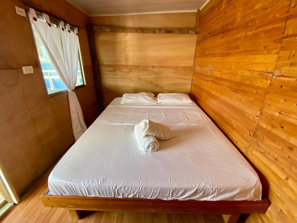 a bedroom with two beds in a wooden room at Eco Hostal Estrella De Mar in Isla Mucura