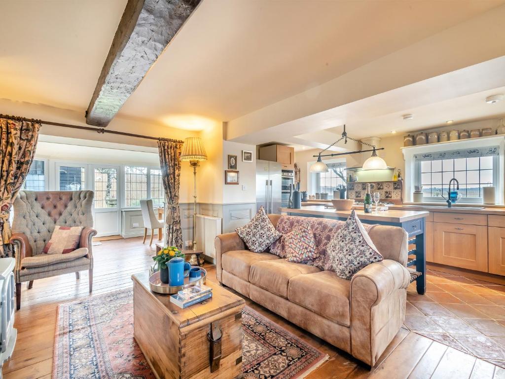 a living room with a couch and a kitchen at Ship Cottage in Reedham