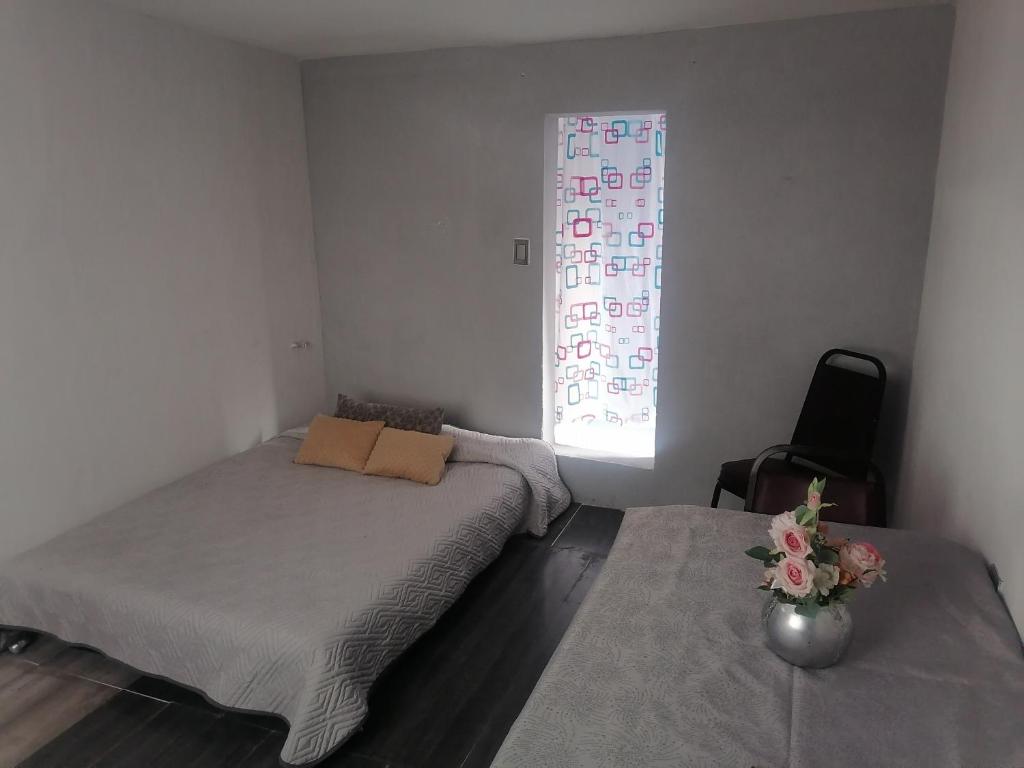 Habitación cómoda para tu estancia, con baño privado في مدينة ميكسيكو: غرفة نوم بسريرين ونافذة