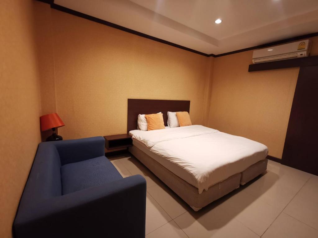 - une chambre avec un lit et une chaise bleue dans l'établissement จินตคามโฮมเพลส/Jintakam Home Place, à Udon Thani