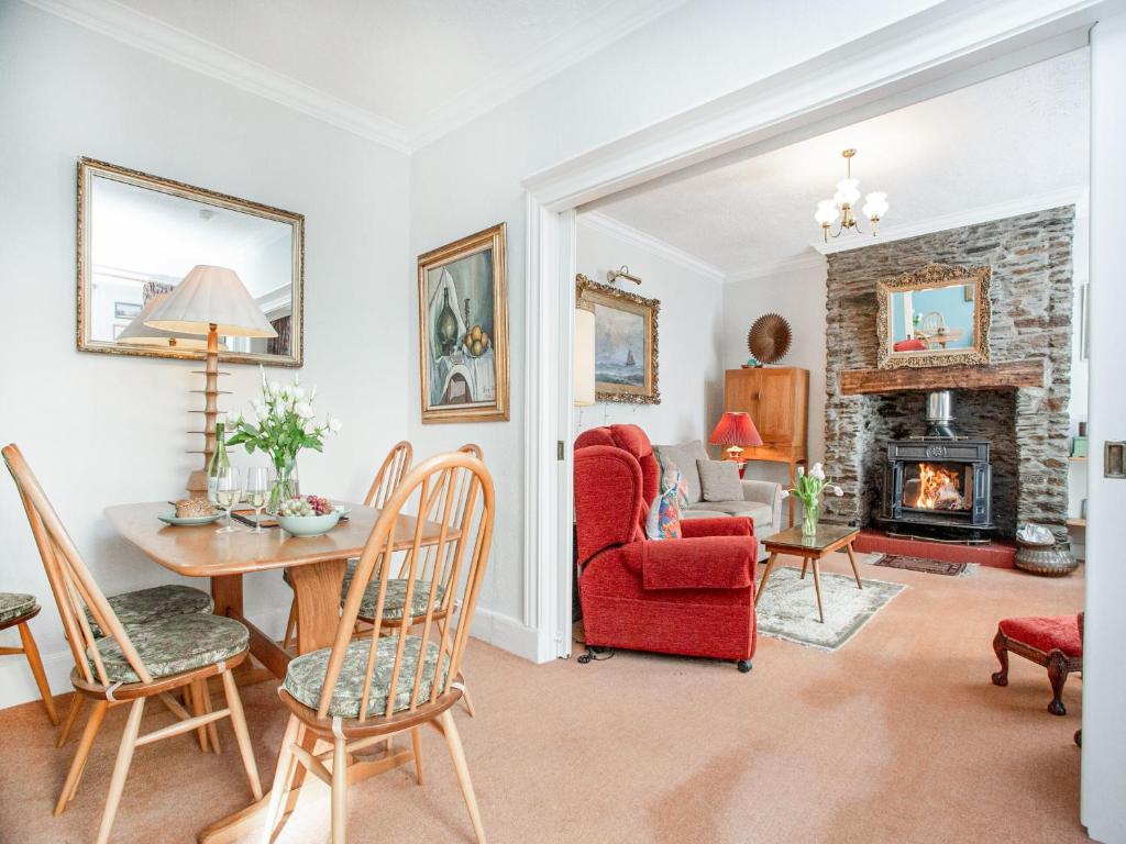 a living room with a red chair and a fireplace at Lee House in Fowey