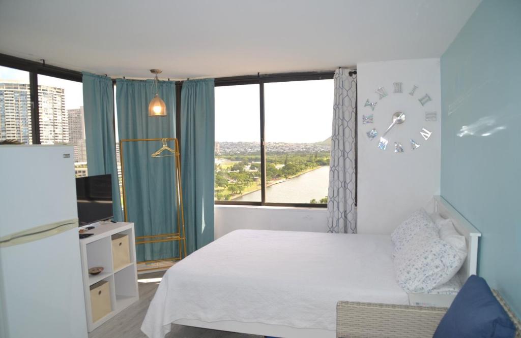 a bedroom with a bed and a clock on the wall at Hawaiian Monarch 1611 condo in Honolulu