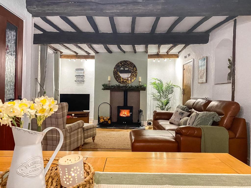 - un salon avec un canapé et une cheminée dans l'établissement Daffodil Cottage, à Cockermouth