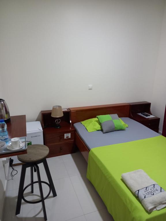 1 dormitorio con 2 camas, mesa y taburete en Nifa House en Espargos