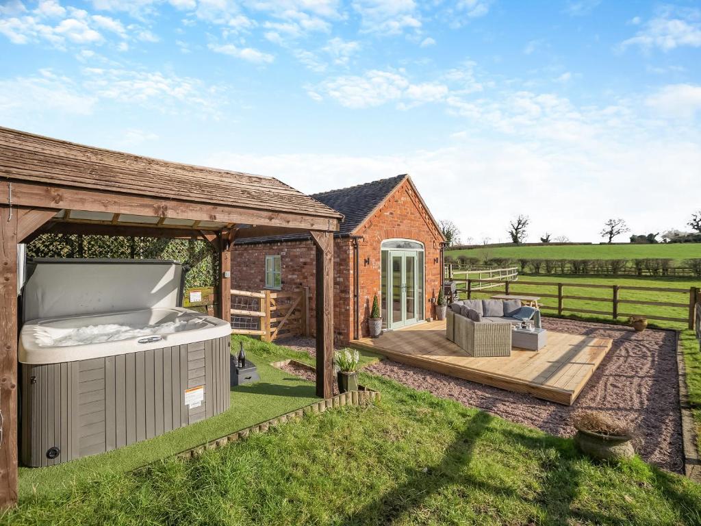 a backyard with a hot tub and a gazebo at Bank House Barn in Audlem