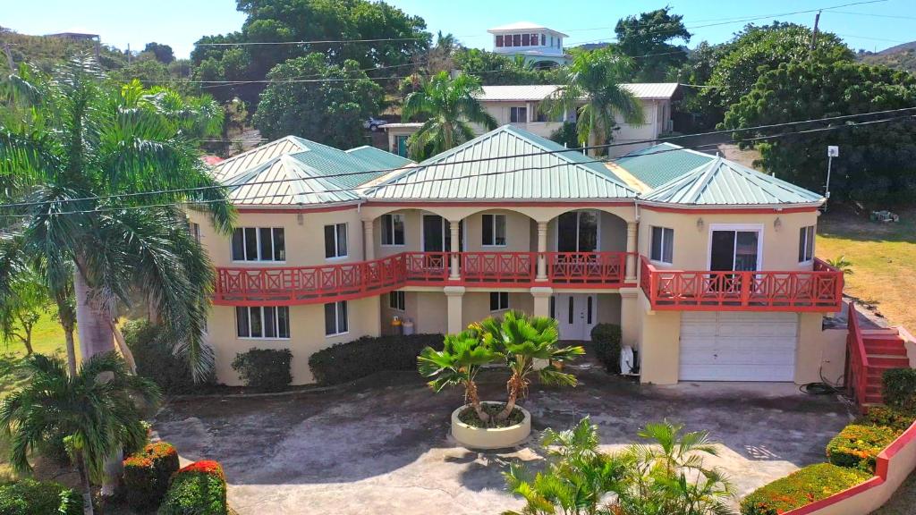 a large white house with a red balcony at Royal Palms Estate in Christiansted