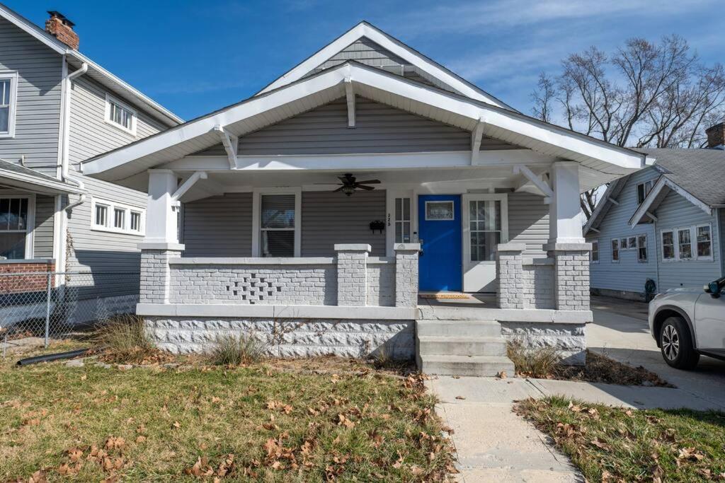 a white house with a blue door at Indy 4-Bedroom Haven: Your Perfect Retreat in Indianapolis