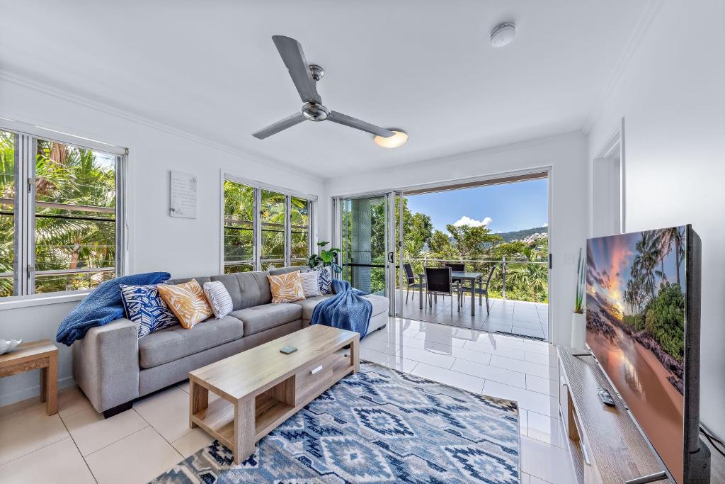 a living room with a couch and a table at Airlie Summit Apartments in Airlie Beach
