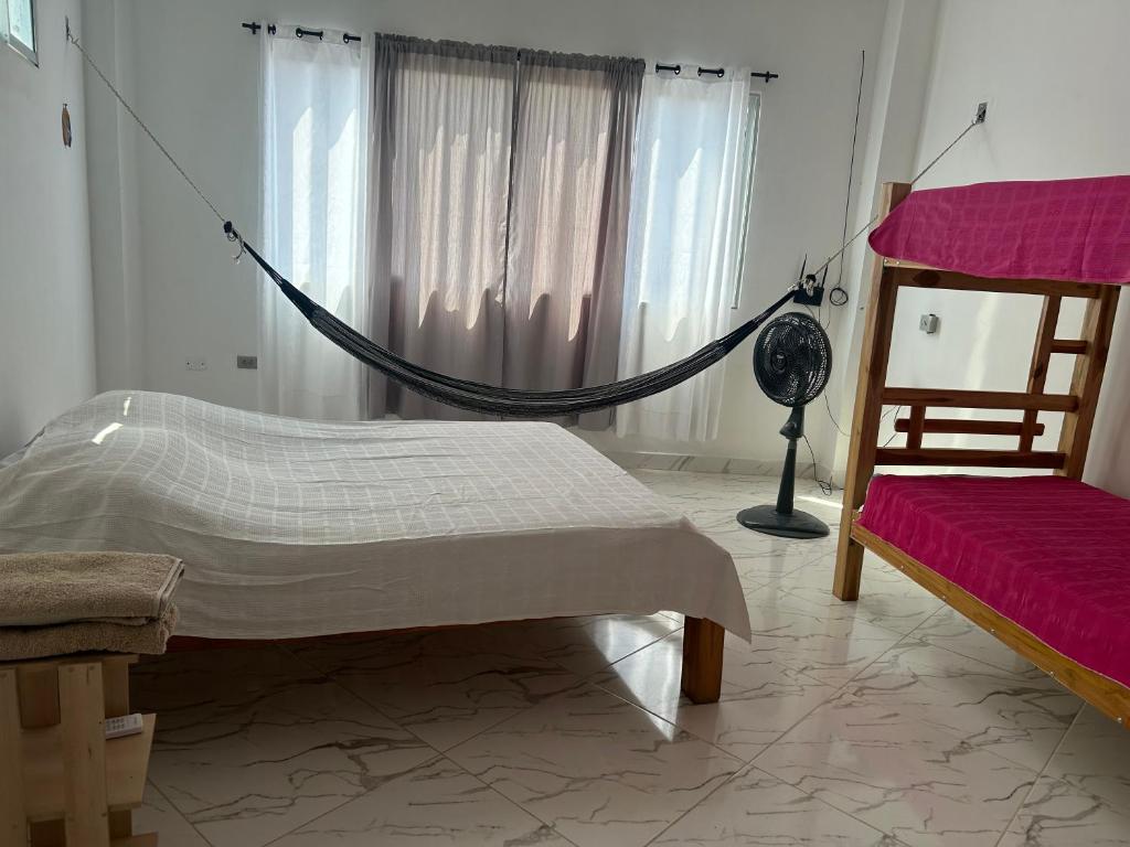a bedroom with a hammock and a bed and a window at Cabaña Maríamar2 in Puerto Escondido