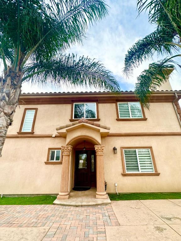 a house with a palm tree in front of it at Qazaq Hostel in Los Angeles