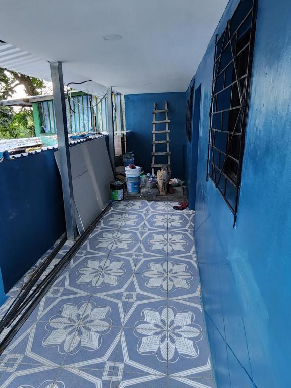 Habitación con pared azul y suelo de baldosa. en Estadia Regalo de Dios, 