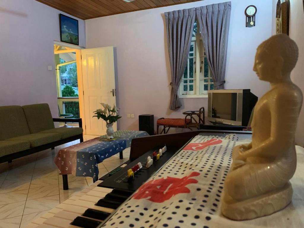 a living room with a statue of a person sitting on a couch at Mohotti House in Galle