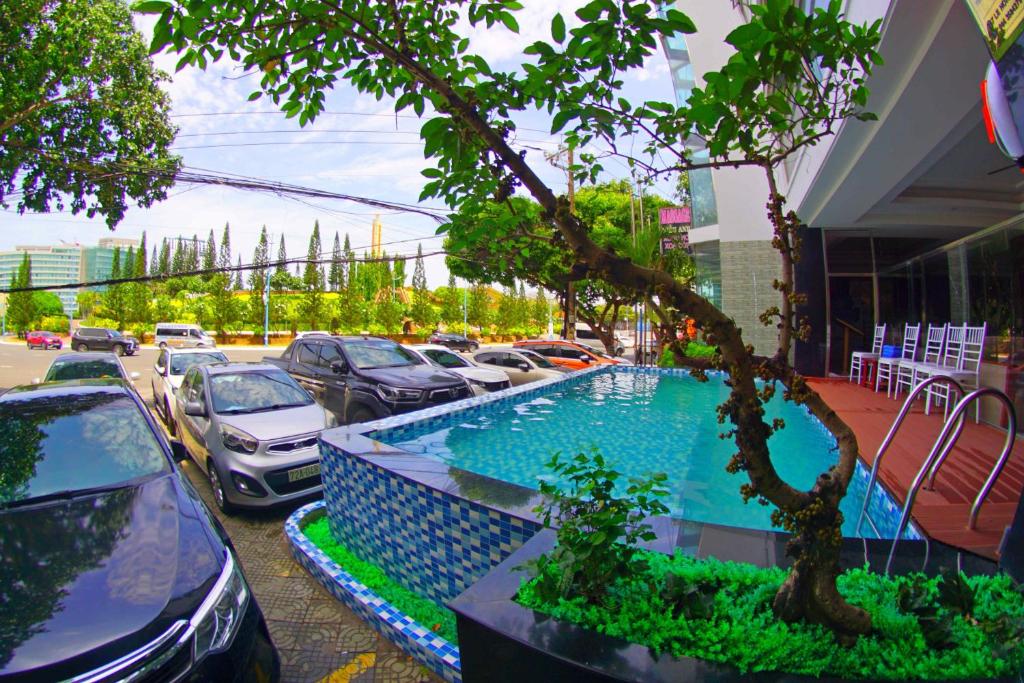 頭頓的住宿－Kieu Anh Hotel Vung Tau，停车场的游泳池,汽车旁