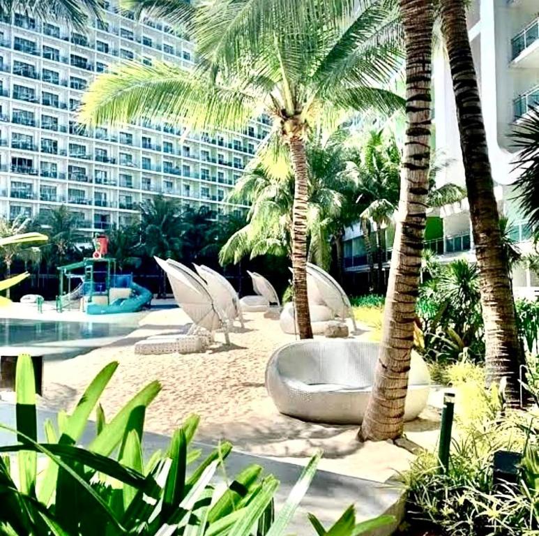 a resort with palm trees and a swimming pool at Azure Urban Residences in Manila