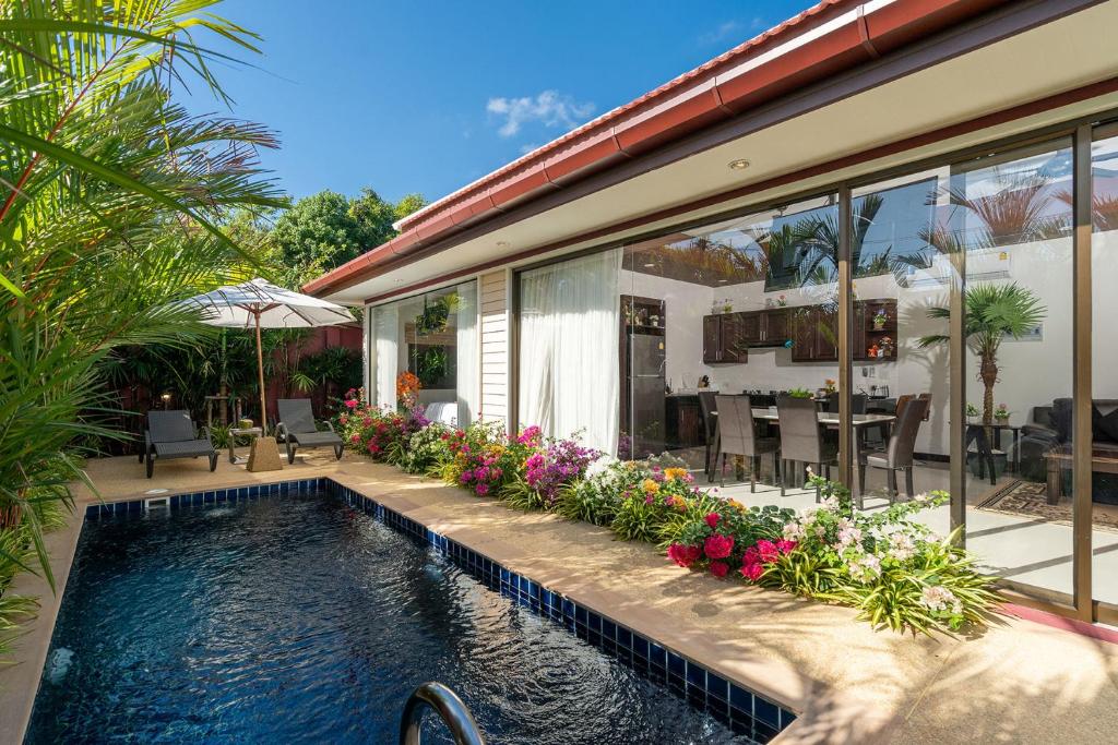ein Haus mit einem Pool vor einem Haus in der Unterkunft Boutique Resort Private Pool Villa - SHA Extra Plus in Ban Pa Khlok