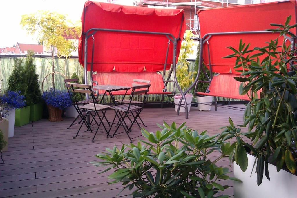 a patio with red chairs and a table on a deck at Peaceful Stay/Heart of Gdansk/Unforgettable in Gdańsk