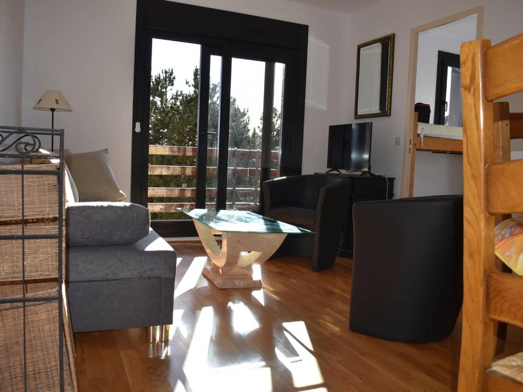 uma sala de estar com um sofá e uma mesa em Appartement Bolquère-Pyrénées 2000, 2 pièces, 4 personnes - FR-1-592-69 em Font Romeu Odeillo Via