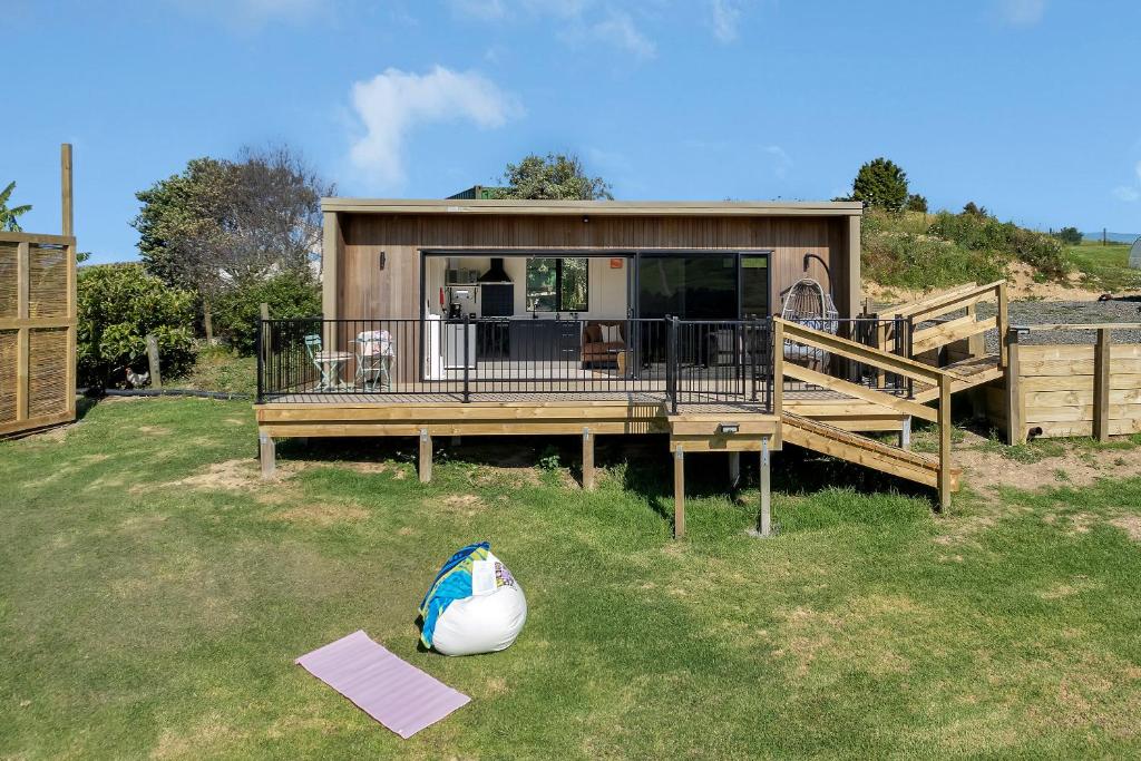 a home with a large deck and a house at Valley View - Whangarei Tiny Home in Whangarei
