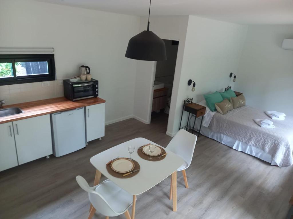 a living room with a bed and a table and chairs at Calma del Bosque in Mar del Plata