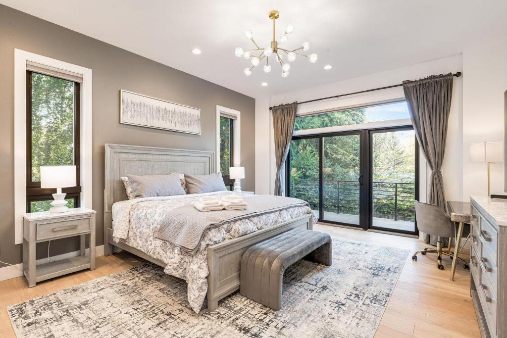 a bedroom with a bed and a desk and windows at Bellevue Splendor Birch Cedar Suite BY Betterstay in Bellevue