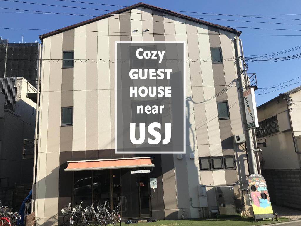 un bâtiment avec un panneau indiquant une maison d'hôtes confortable près de nous dans l'établissement USJに一番近いゲストハウス J-Hoppers Osaka Universal, à Osaka