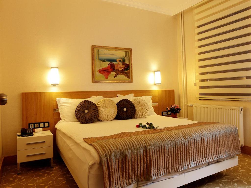 a bedroom with a large bed with pillows on it at Sultan Hotel in Sivas