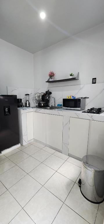a kitchen with white cabinets and a black refrigerator at Departamento por plaza terraza oblatos in Guadalajara