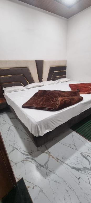 een bed met een bruine deken erop bij Hotel StarLight By i line in Ujjain