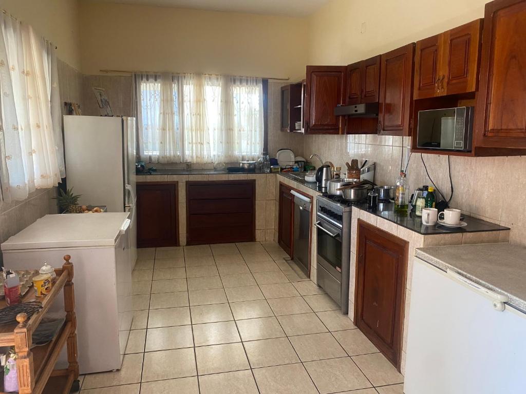 a kitchen with wooden cabinets and a white refrigerator at AEROPARK RESIDENCIAL2 in Maputo