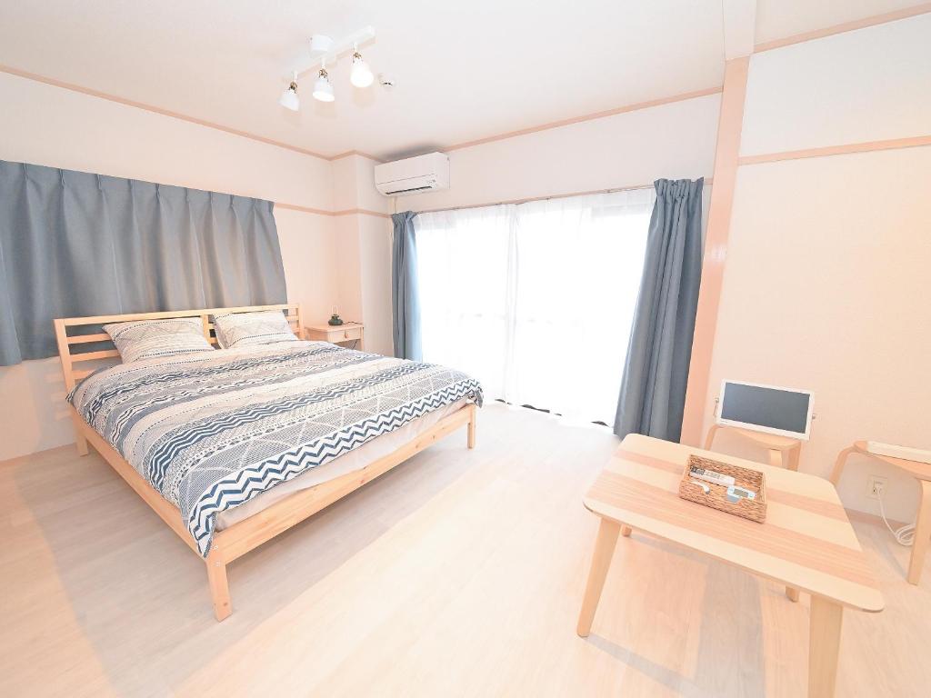 a bedroom with a bed and a large window at Residence Hotel Kamoike in Kagoshima