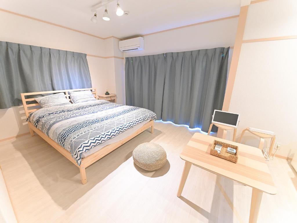 1 dormitorio con 1 cama grande y 1 mesa en Residence Hotel Kamoike, en Kagoshima