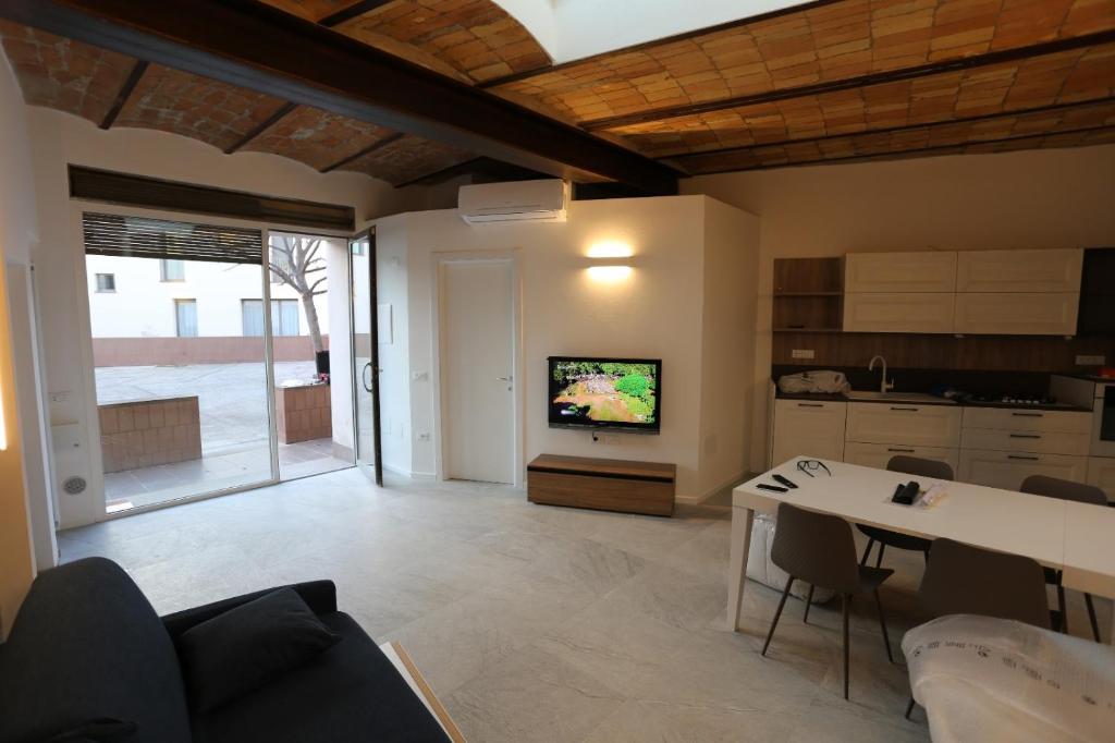 a kitchen and living room with a table and a tv at Porta del centro in Gubbio