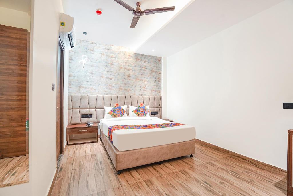 a bedroom with a bed and a brick wall at FabHotel The Comfort Inn in Kānpur
