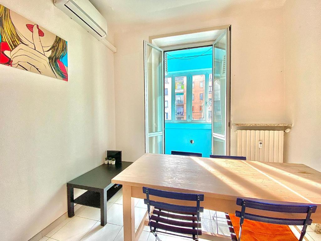 a table and chairs in a room with a window at Washington apartment in Milan