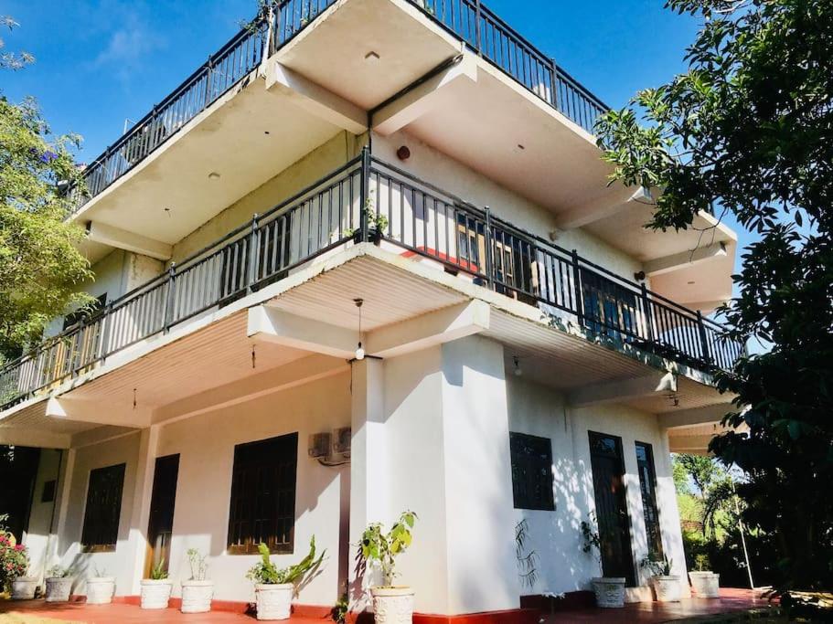 a white building with a balcony on top of it at Adisham village home in Haputale