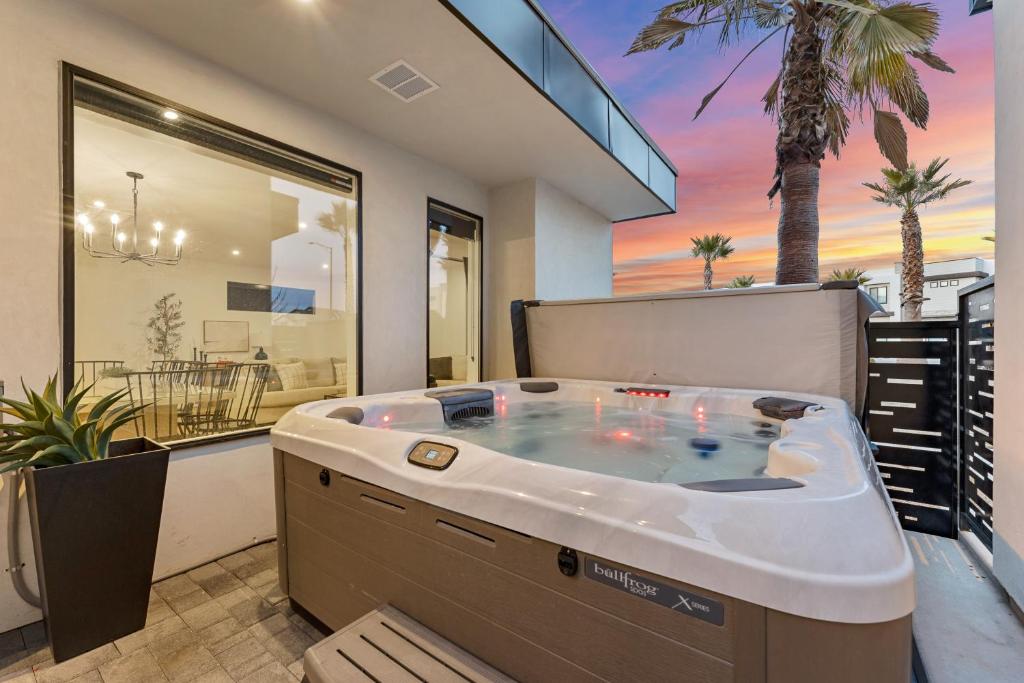 une baignoire jacuzzi dans une maison avec un palmier dans l'établissement Palm Desert Oasis townhouse, à Atkinville