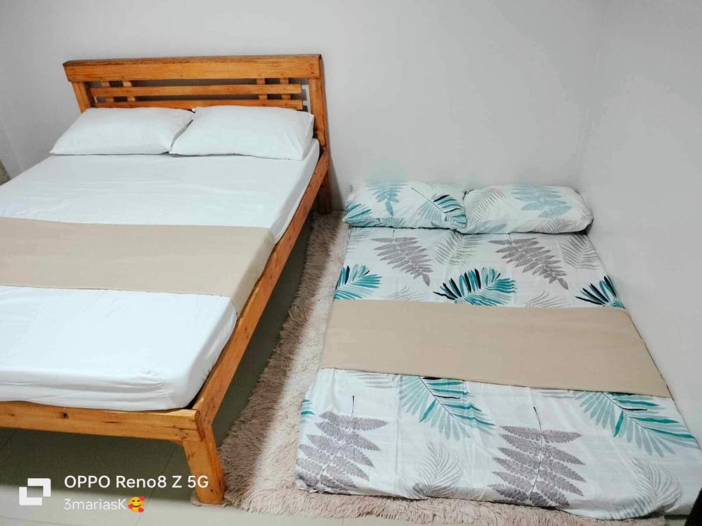 two twin beds in a room with a wall at 3K’s Transient house in Bagac in Malawin