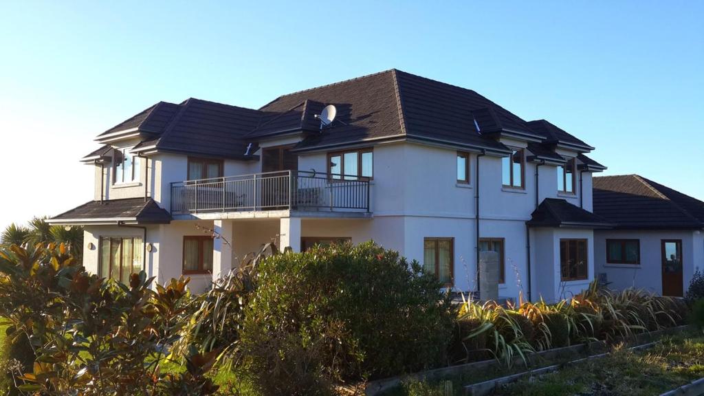 una casa blanca con techo negro en Kaikoura Mountain Views Villa en Kaikoura