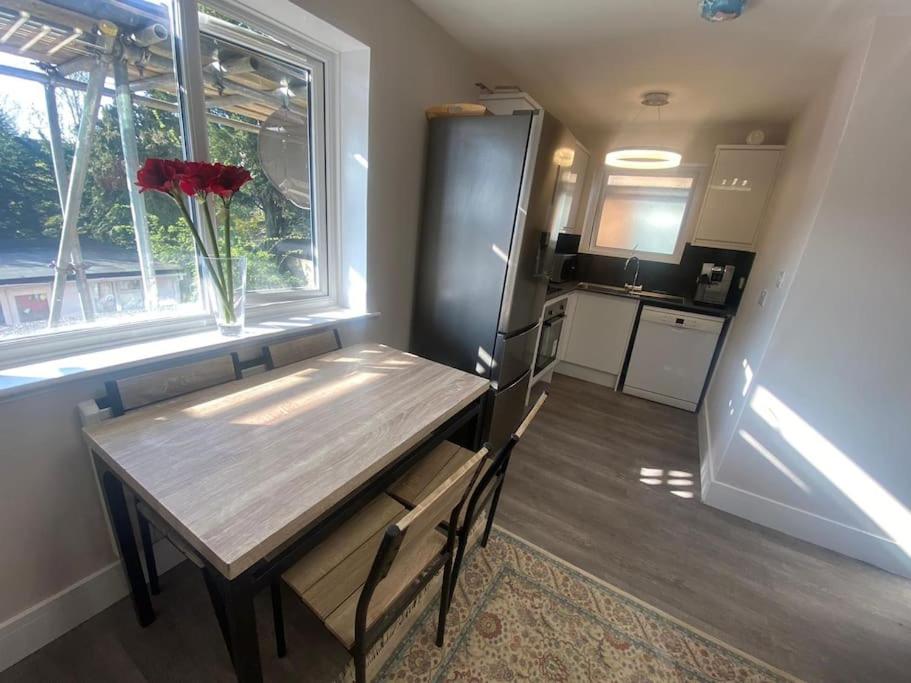 une petite cuisine avec une table en bois et une fenêtre dans l'établissement NEW! Brand New Beautiful Modern Apartment, à Londres