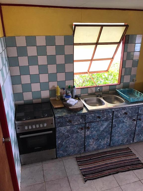 una cocina con fregadero y estufa en Fare OKAI, en Fitii